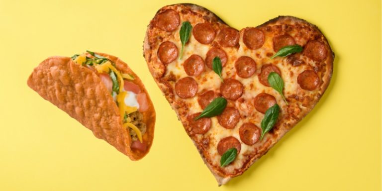 A taco and a heart shaped pizza side by side